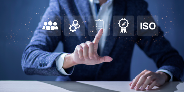 A group of smartly dressed office workers. There are four people fully in frame and they are all smiling happily and enjoying their work.